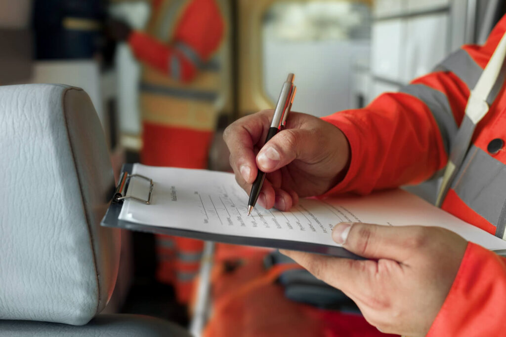 Ambulance staff documenting stretcher ambulance service details