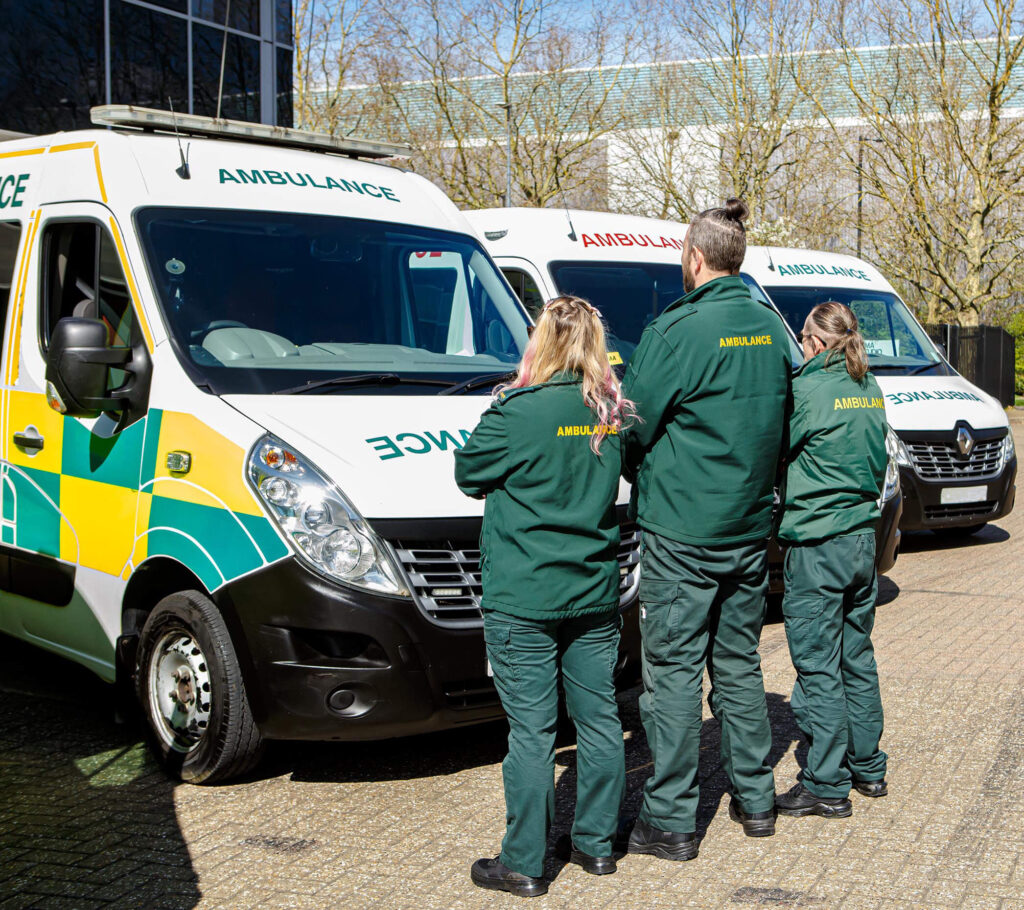Ambulance staff team discussion beside vehicles